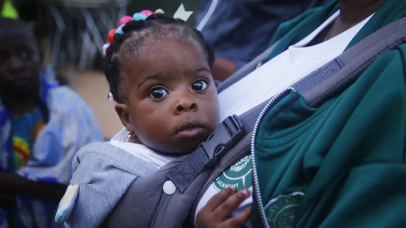 A baby carried on a parent’s back at the match-day event